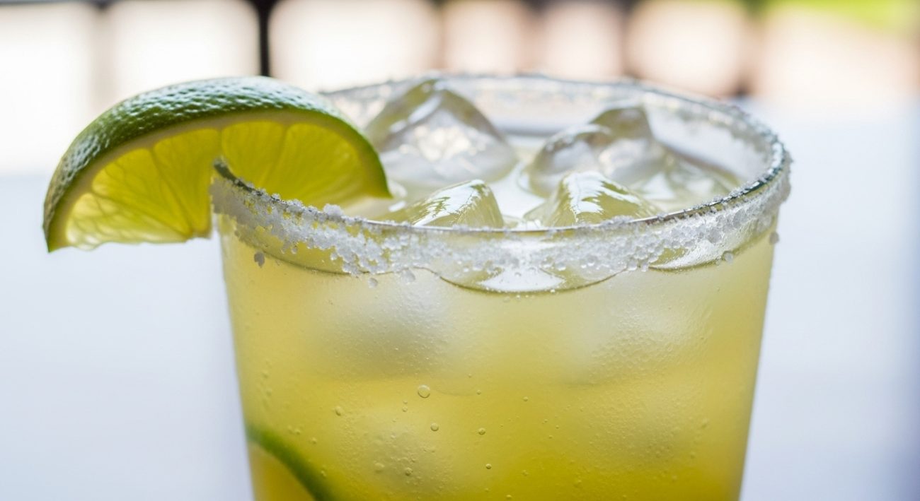 Classic margarita cocktail with lime and salt rim in a glass